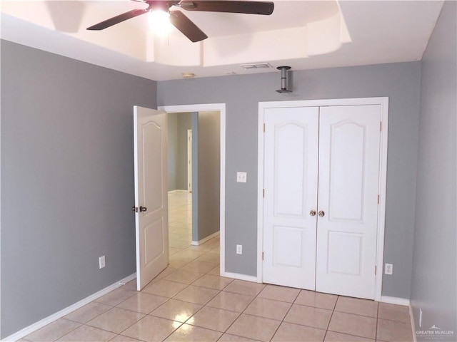 unfurnished bedroom featuring ceiling fan, a closet, and light tile patterned floors