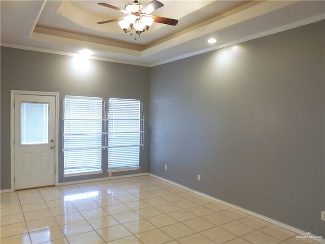 tiled spare room with ceiling fan, a raised ceiling, and crown molding