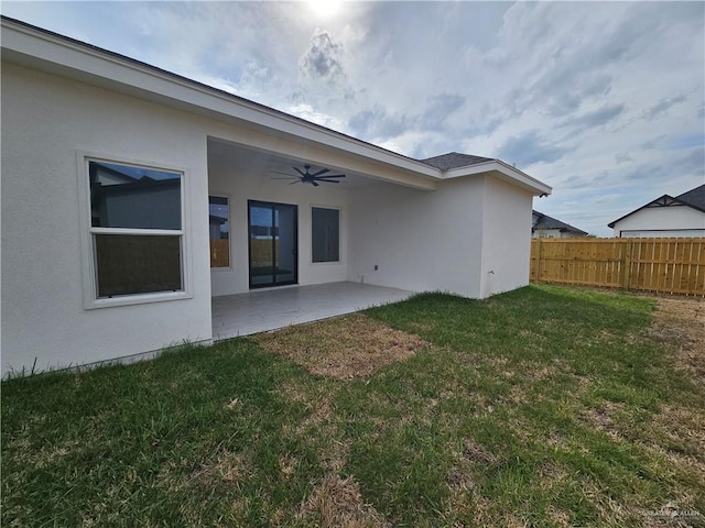 rear view of house with a yard, a patio, and ceiling fan