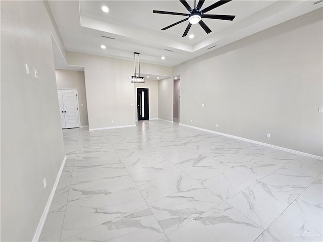 spare room with a raised ceiling and ceiling fan