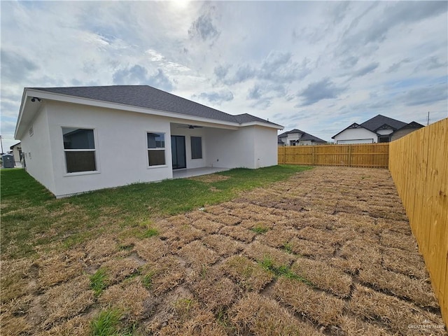 back of house with a lawn and a patio