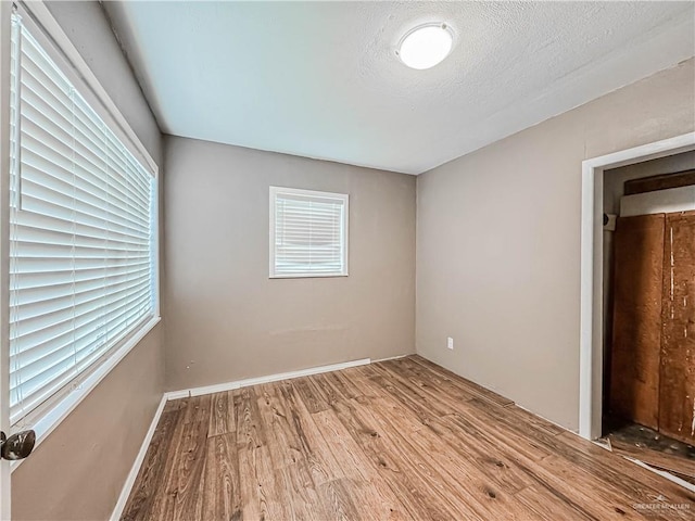 unfurnished bedroom featuring wood-type flooring and a textured ceiling