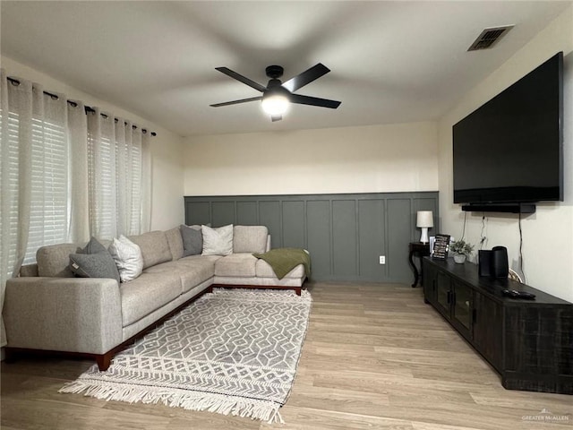9216 N 31st St, Mcallen, TX 78504 - living area featuring light wood-style floors, ceiling fan, a decorative wall, and wainscoting