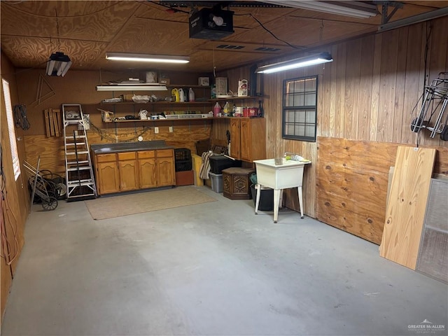 interior space with a workshop area, wooden walls, and a garage door opener