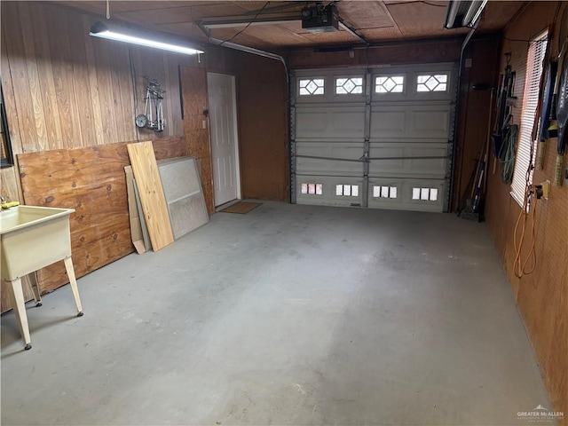 garage with a garage door opener and wooden walls