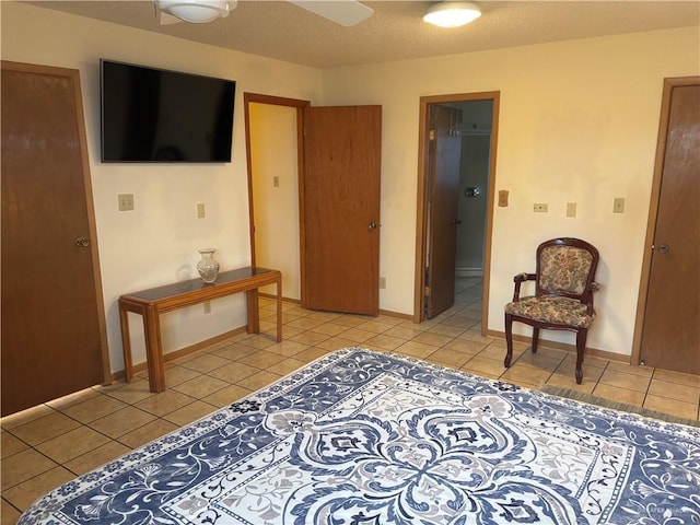 interior space with light tile patterned floors, a textured ceiling, and ceiling fan