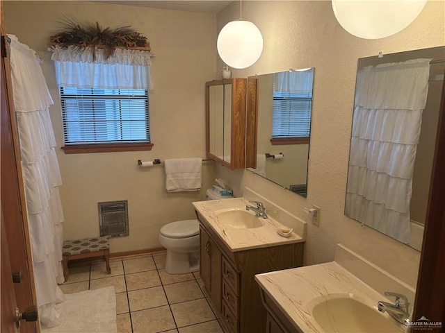 bathroom with toilet, vanity, and tile patterned floors