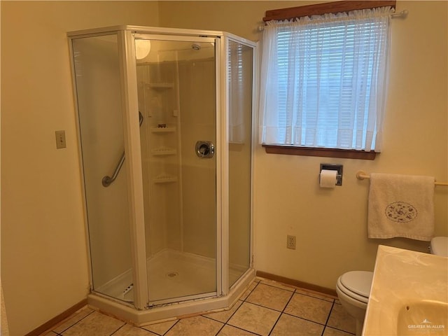 bathroom with tile patterned floors, a shower with door, vanity, and toilet