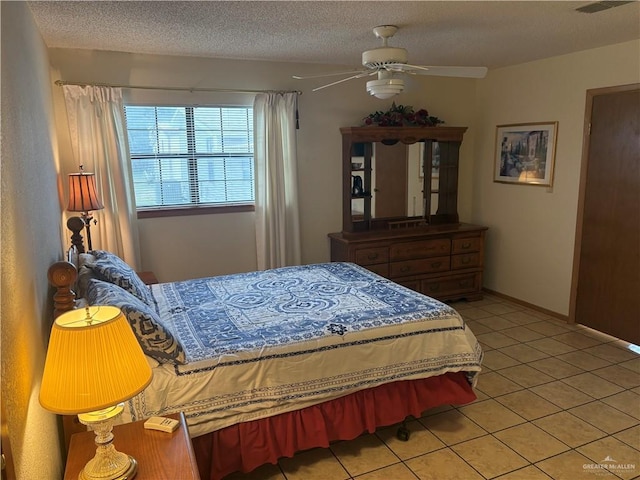 tiled bedroom with a textured ceiling and ceiling fan