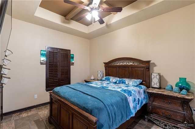 bedroom with ceiling fan and a raised ceiling