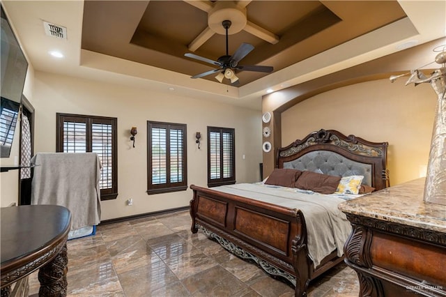 bedroom with a raised ceiling and ceiling fan