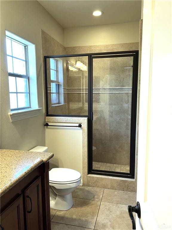 bathroom featuring tile patterned floors, vanity, toilet, and an enclosed shower