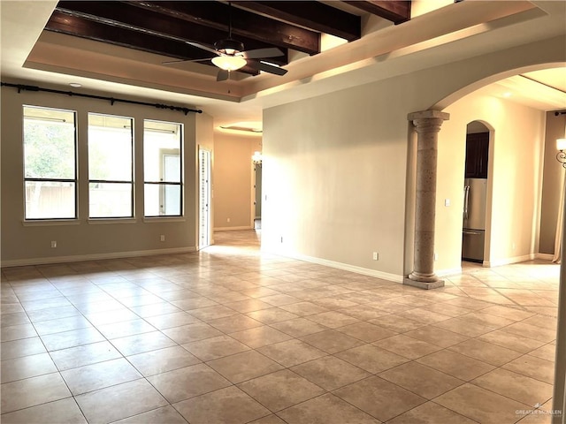 tiled empty room featuring beam ceiling, decorative columns, ceiling fan, and a tray ceiling