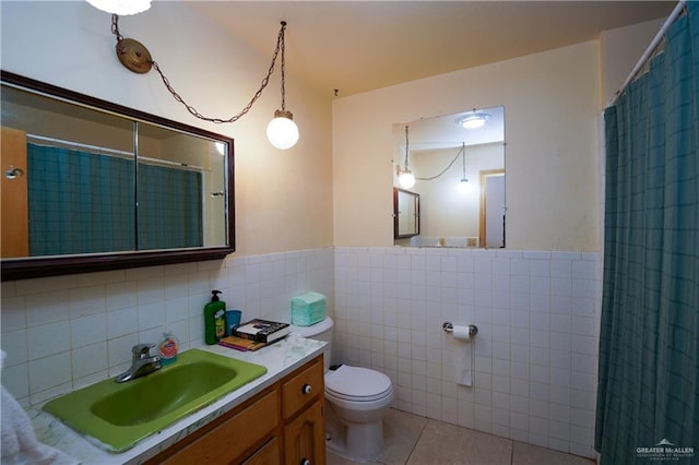 603 S Alamo Rd, Alamo, TX 78516 - full bathroom with wainscoting, toilet, tile patterned floors, tile walls, and a shower with curtain