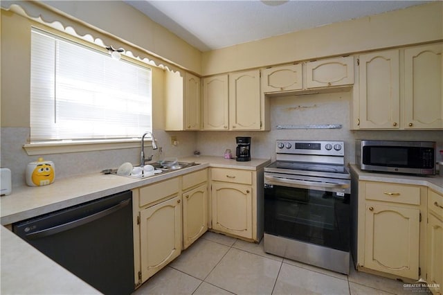 603 S Alamo Rd, Alamo, TX 78516 - kitchen featuring light tile patterned flooring, appliances with stainless steel finishes, a sink, light countertops, and cream cabinetry