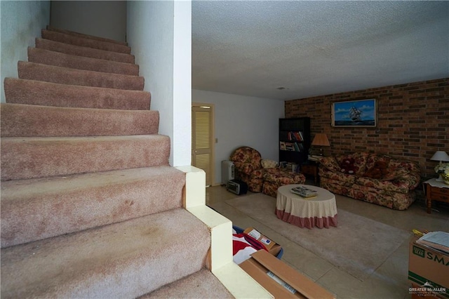 603 S Alamo Rd, Alamo, TX 78516 - staircase featuring a textured ceiling and brick wall