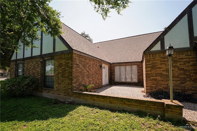 603 S Alamo Rd, Alamo, TX 78516 - view of side of property with roof with shingles, a lawn, a patio area, and brick siding