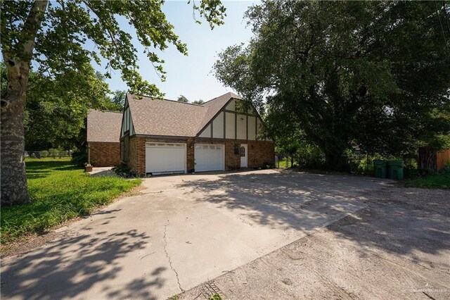 603 S Alamo Rd, Alamo, TX 78516 - view of front of property featuring a garage, concrete driveway, roof with shingles, and brick siding