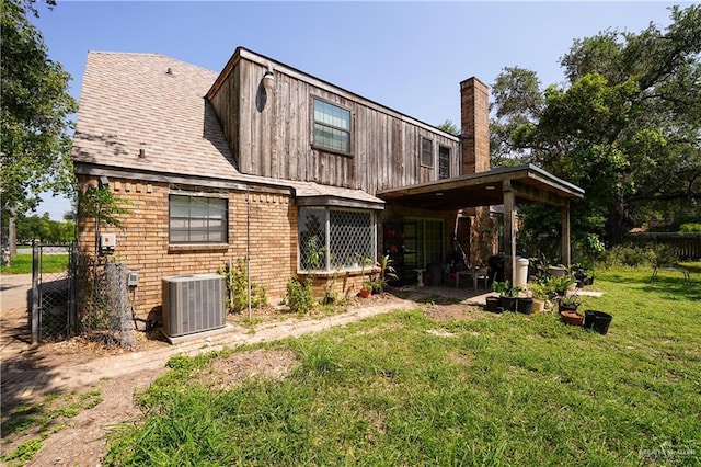 603 S Alamo Rd, Alamo, TX 78516 - rear view of house featuring central air condition unit, fence, a chimney, and a yard