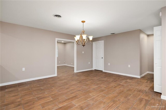 524 Palm Valley Dr E, Harlingen, TX 78552 - empty room with a chandelier, baseboards, and light wood-style flooring