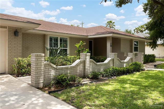 524 Palm Valley Dr E, Harlingen, TX 78552 - ranch-style home featuring brick siding, a front yard, and a shingled roof