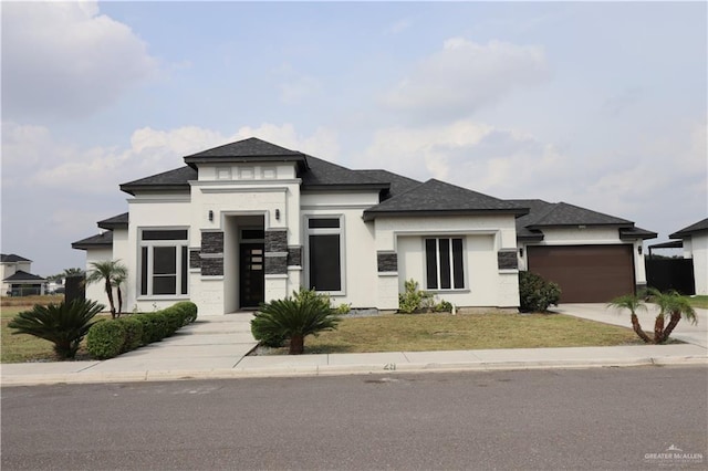 1005 Platinum St, Mission, TX 78572 - prairie-style house with driveway, an attached garage, a shingled roof, stucco siding, and a front yard