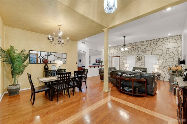 dining area featuring decorative columns, hardwood / wood-style floors, and ceiling fan with notable chandelier