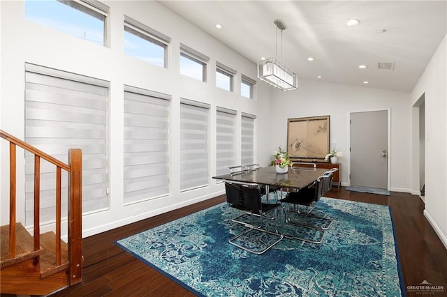 dining space featuring vaulted ceiling and dark hardwood / wood-style floors