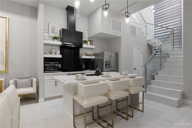102 E Whiting St Unit A & B, South Padre Island, TX 78597 - kitchen with stainless steel fridge, open shelves, light countertops, a breakfast bar area, and a kitchen island