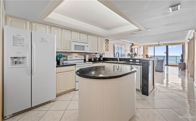 kitchen with a peninsula, a sink, visible vents, white appliances, and light tile patterned floors