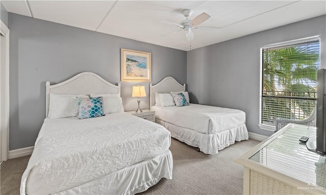 bedroom with ceiling fan, baseboards, and carpet flooring