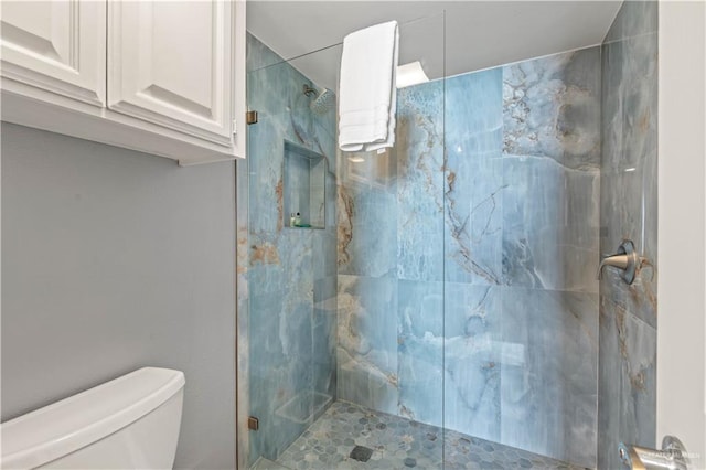 full bathroom featuring toilet and a marble finish shower