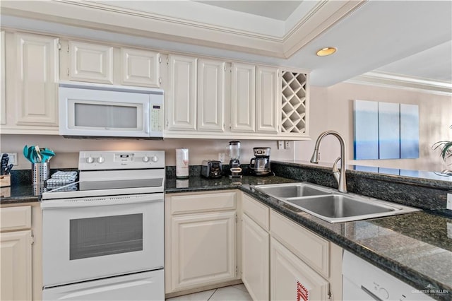 kitchen with dark stone countertops, crown molding, a sink, and white appliances