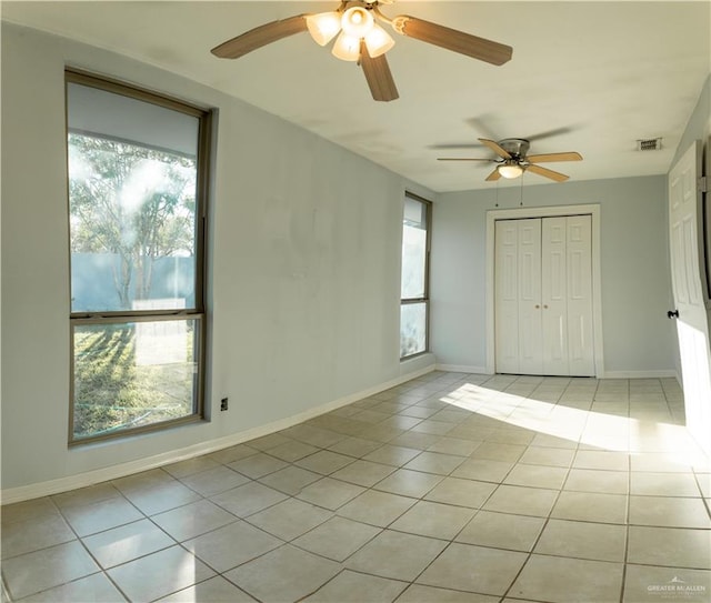 unfurnished bedroom with a closet, multiple windows, and ceiling fan