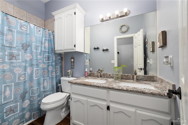 bathroom with curtained shower, a sink, toilet, and double vanity