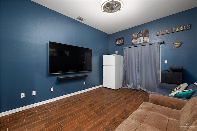 unfurnished living room featuring wood tiled floor, visible vents, and baseboards