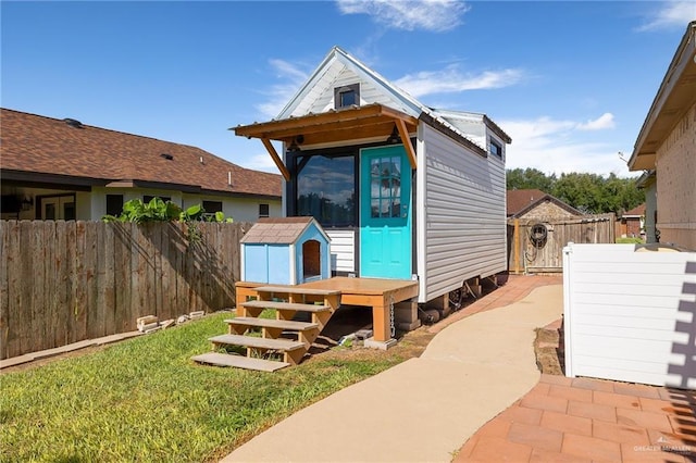 exterior space featuring an outbuilding, a front yard, and a fenced backyard