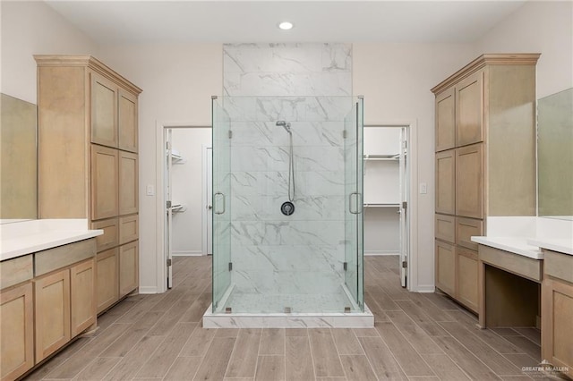 bathroom with a shower with door and vanity