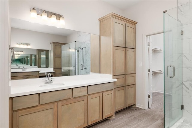 bathroom with hardwood / wood-style floors, vanity, and a shower with shower door