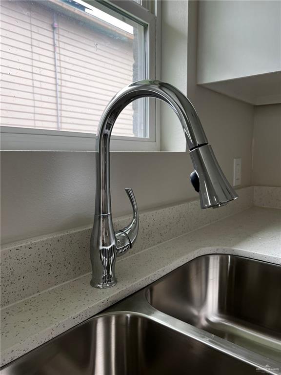 details featuring light stone counters and sink