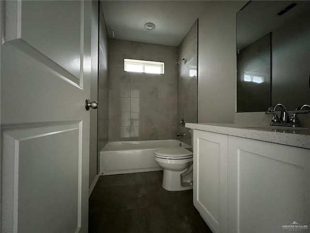 full bathroom featuring vanity, tiled shower / bath combo, toilet, and tile patterned flooring