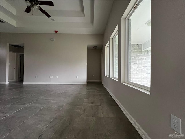 unfurnished room with a tray ceiling and ceiling fan