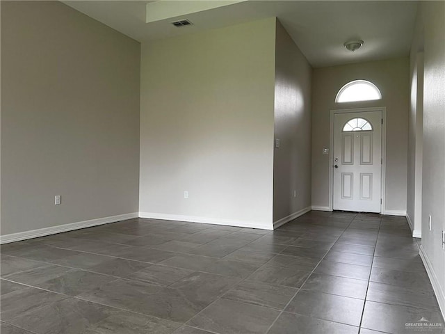 foyer with dark tile patterned flooring and a high ceiling