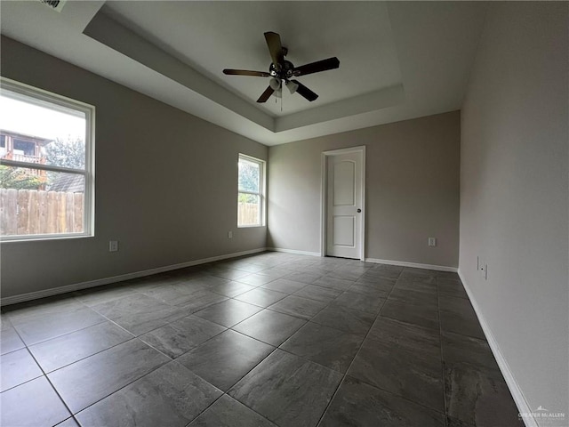 unfurnished room with a tray ceiling and ceiling fan