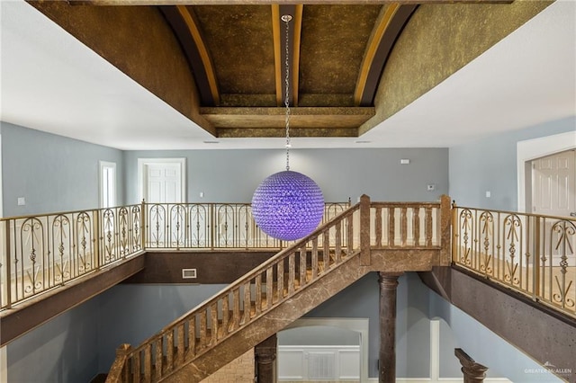 staircase featuring a high ceiling and ornate columns