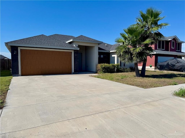 8706 Pink Flamingo St, Harlingen, TX 78552 - view of front of home with an attached garage, driveway, stucco siding, and roof with shingles