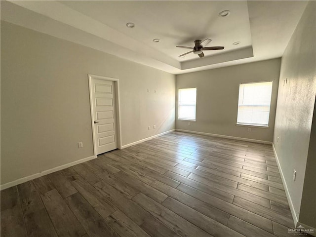 8706 Pink Flamingo St, Harlingen, TX 78552 - unfurnished room with a ceiling fan, dark wood-type flooring, a tray ceiling, and baseboards