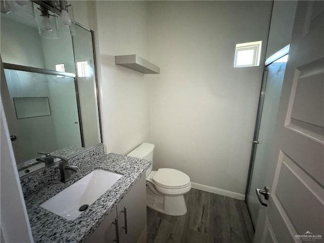 8706 Pink Flamingo St, Harlingen, TX 78552 - bathroom featuring wood finished floors, toilet, baseboards, and vanity