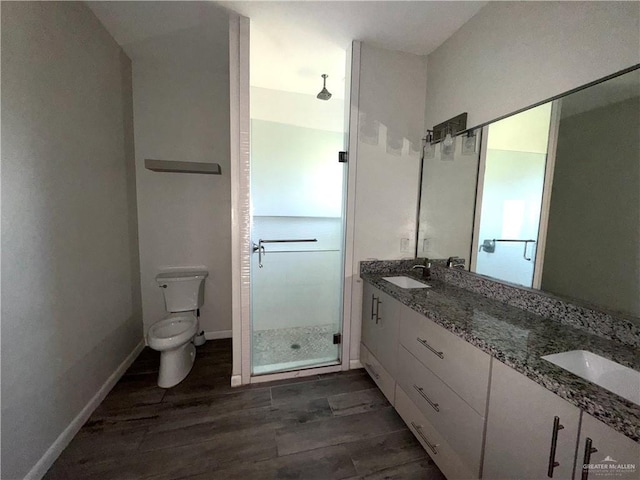 8706 Pink Flamingo St, Harlingen, TX 78552 - bathroom with a shower stall, wood finished floors, double vanity, toilet, and baseboards