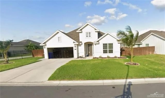 view of front facade featuring an attached garage, fence, driveway, and a front lawn